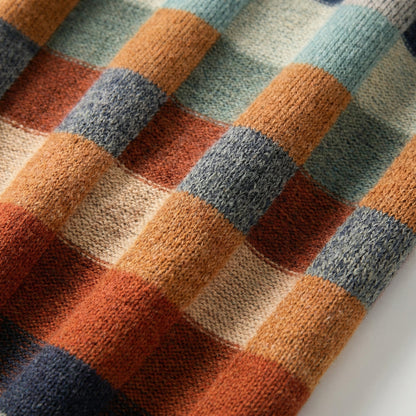 Nahaufnahme bunter kariert gestrickter Pullover mit grober Maschenstruktur in warmen und kühlen Farbtönen