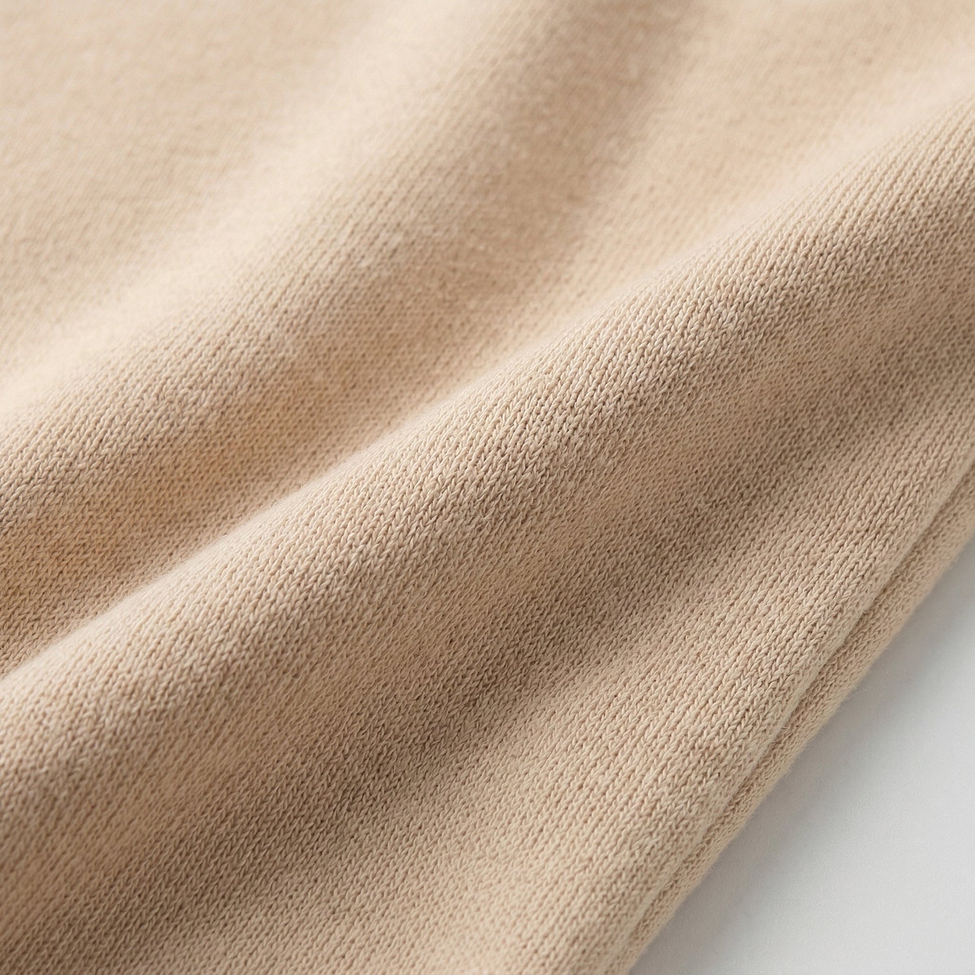 Beiger feiner Strickstoff mit glatter, weicher Textur, Nahaufnahme