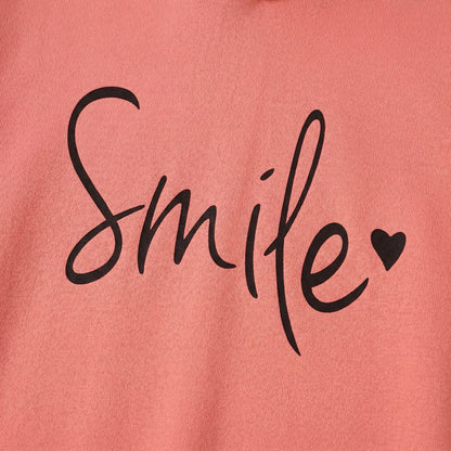 Korallroter Pullover mit schwarzem handschriftlichem Schriftzug 'Smile' und Herzdetail