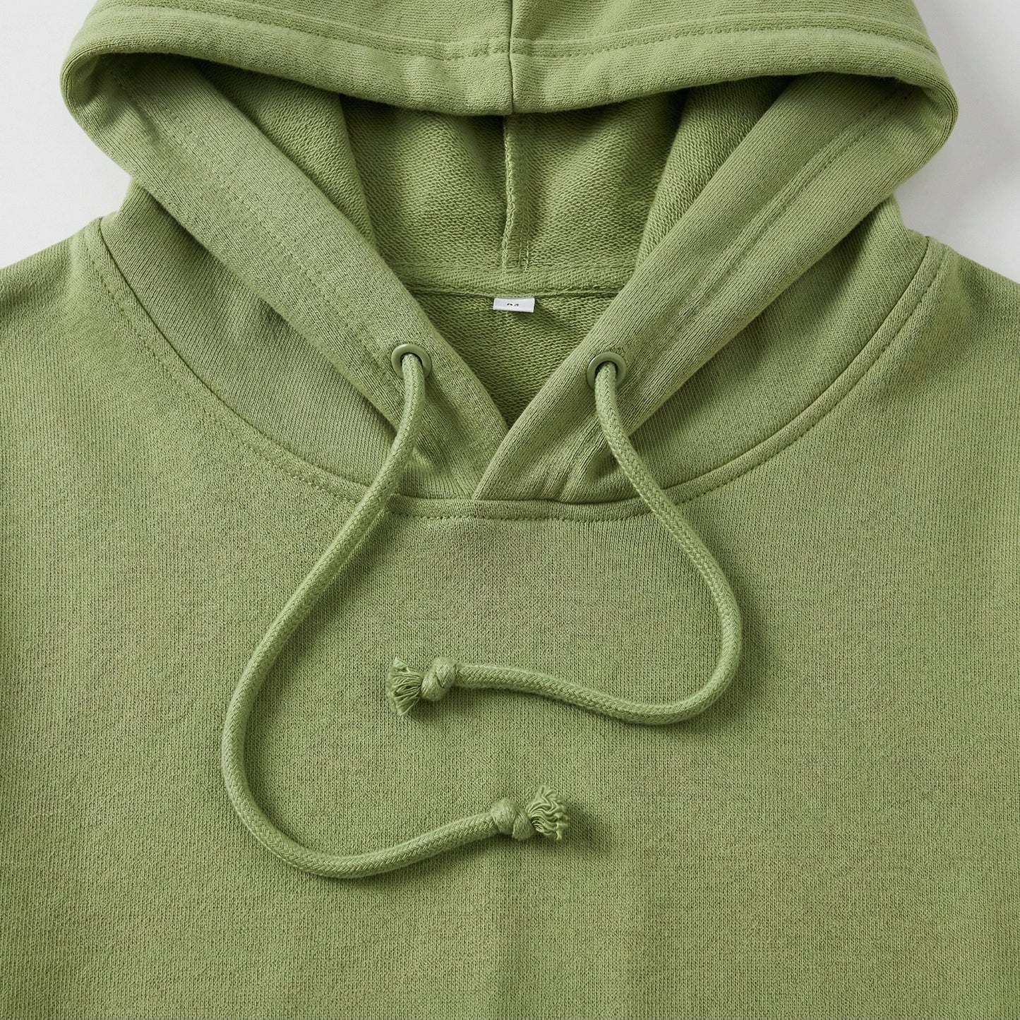 Olivgrüner Hoodie mit Kapuze und Kordelzug, Nahaufnahme der Kapuzenpartie und Stoffstruktur