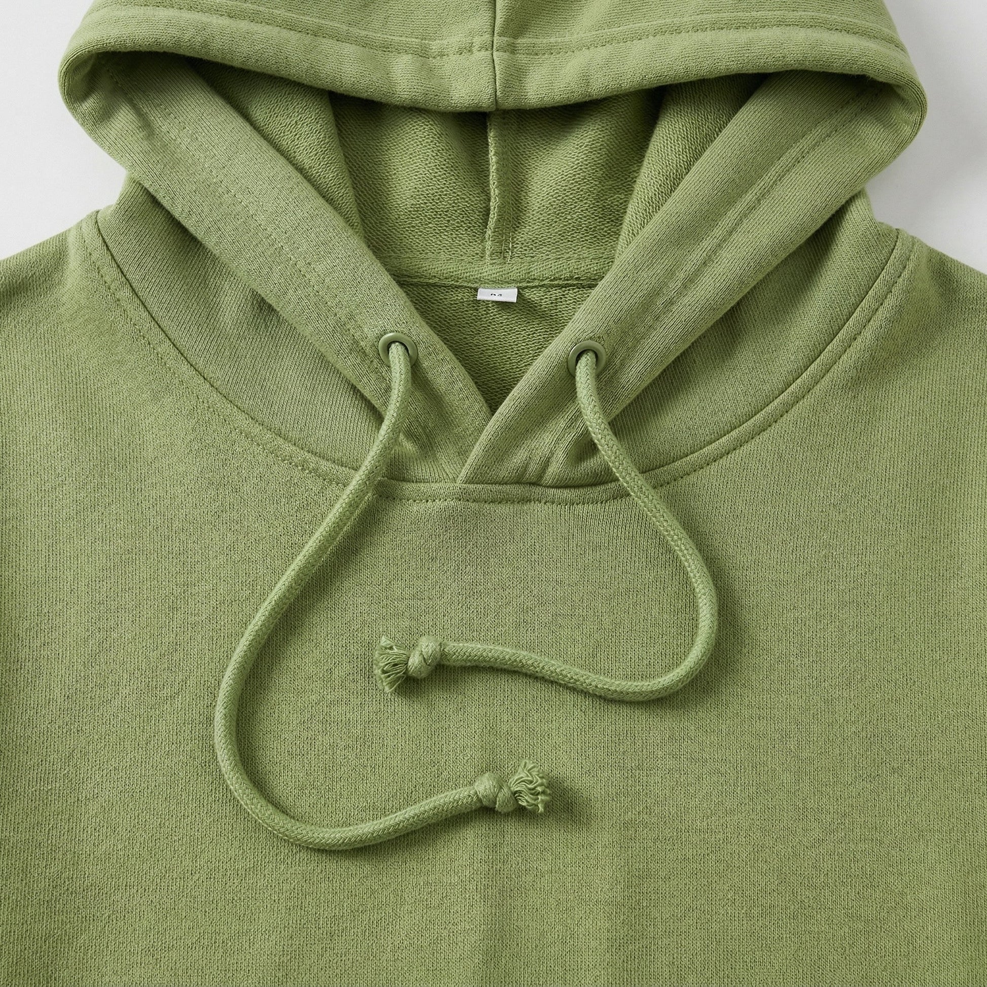 Olivgrüner Hoodie mit Kapuze und Kordelzug, Nahaufnahme der Kapuzenpartie und Stoffstruktur