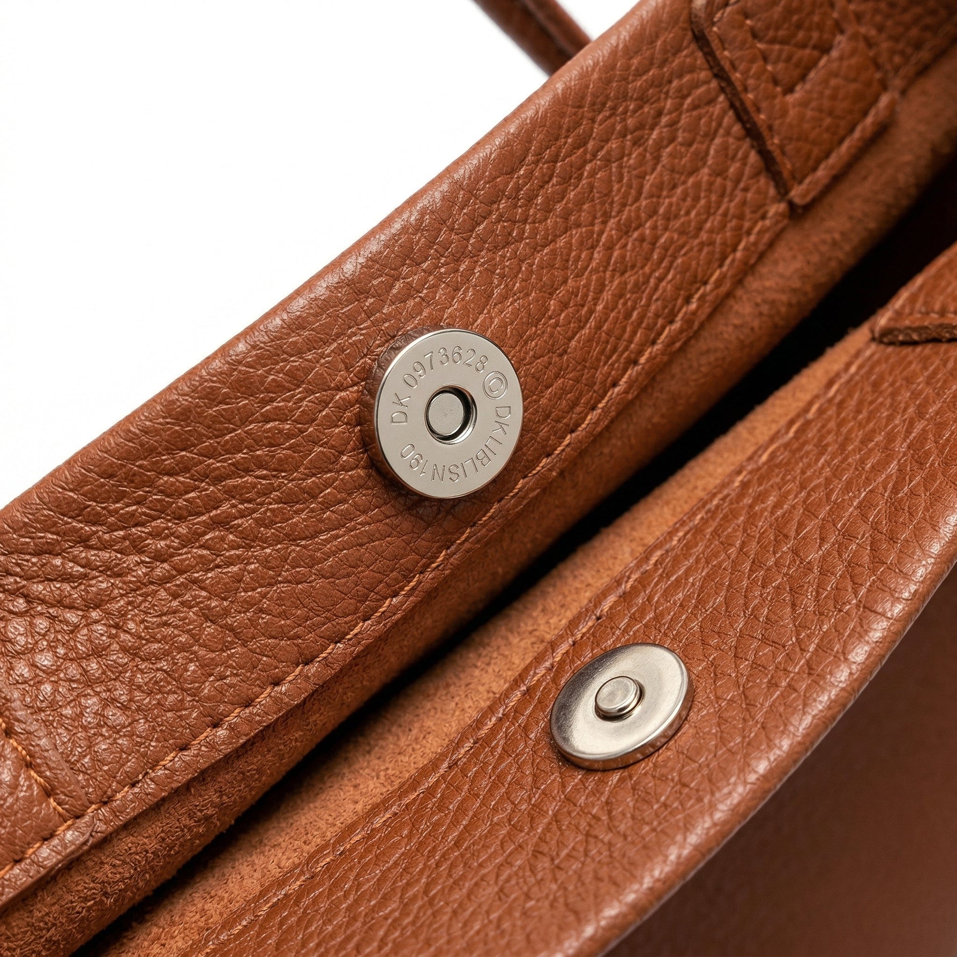 Braune Schultertasche aus genarbtem Leder mit silbernem Magnetverschluss, Nahaufnahme