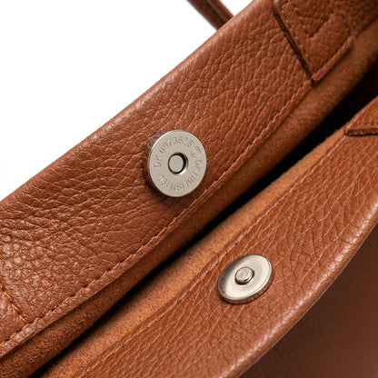 Braune Schultertasche aus genarbtem Leder mit silbernem Magnetverschluss, Nahaufnahme