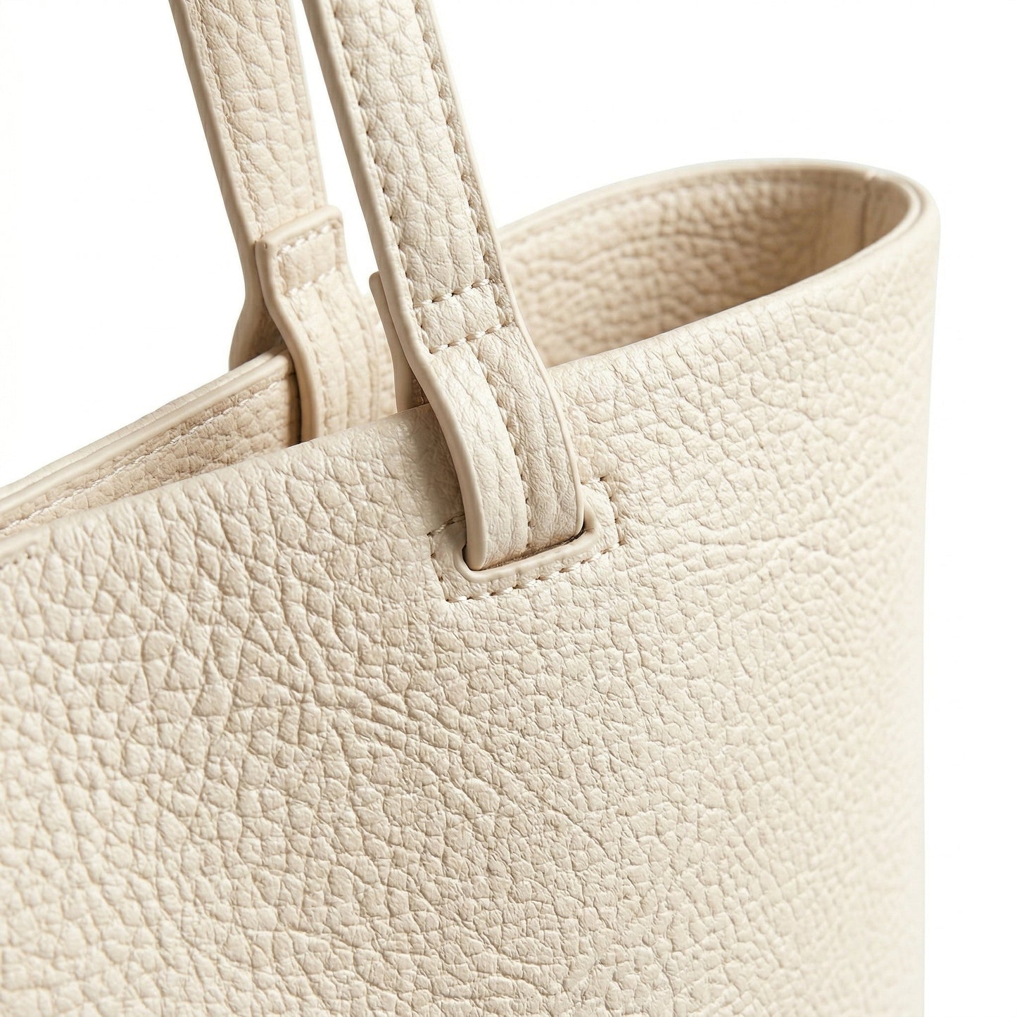 Cremefarbene Schultertasche aus genarbtem Kunstleder mit zwei Tragegriffen, Detailansicht