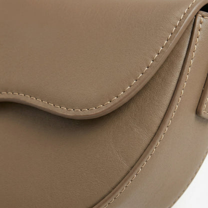 Nahaufnahme hellbraune Saddle Bag aus glattem PU-Leder mit feiner Naht und Besatz