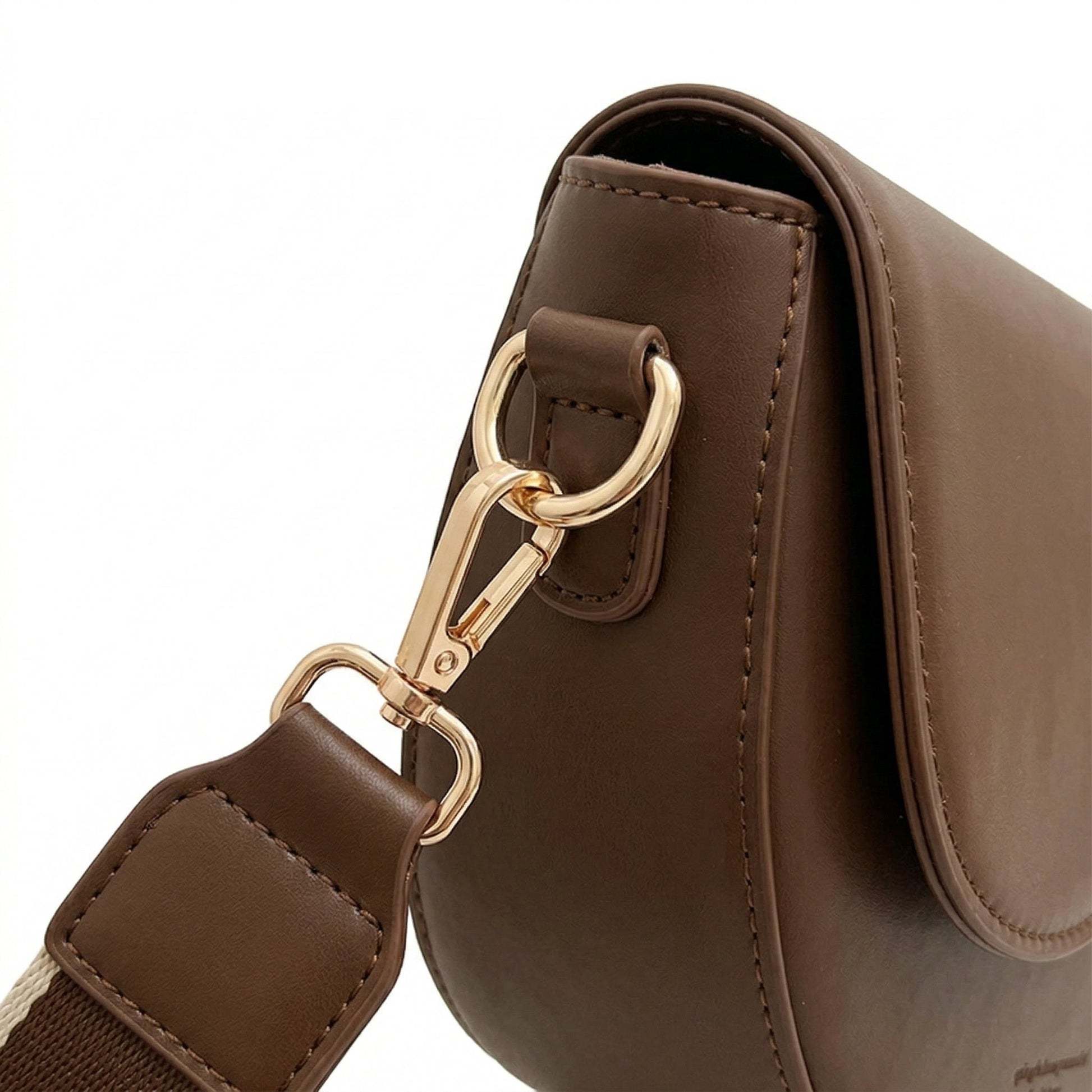 Seitlicher Detailblick auf dunkelbraune PU-Leder Saddle Bag mit goldfarbenem Karabiner und breitem Stoffriemen