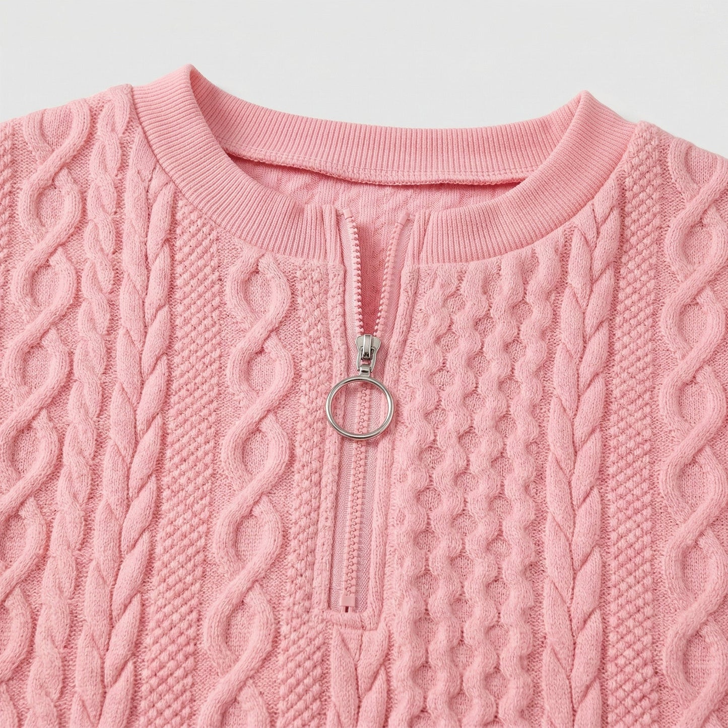 Hellrosa grob gestrickter Damenpullover mit Zopfmuster und rundem Reißverschlussanhänger, Nahaufnahme