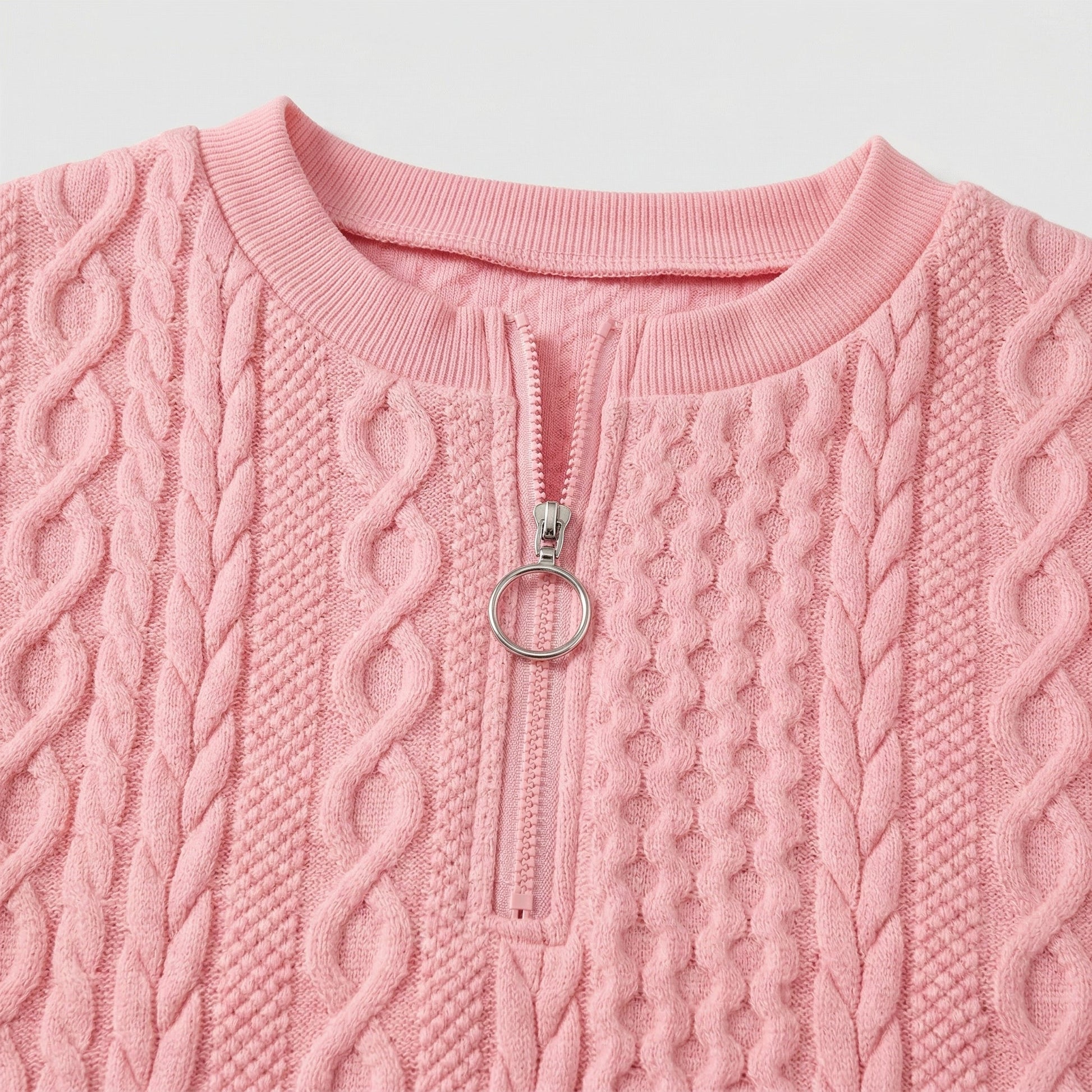 Hellrosa grob gestrickter Damenpullover mit Zopfmuster und rundem Reißverschlussanhänger, Nahaufnahme