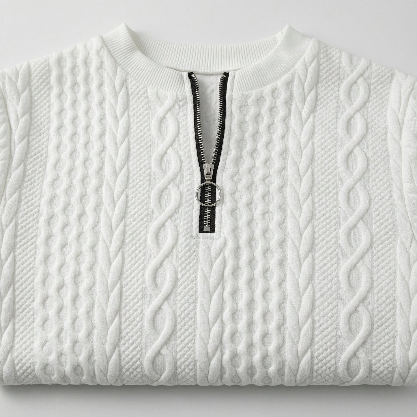 Weißer Strickpullover mit Zopfmuster und kurzem schwarzen Reißverschluss mit rundem Metallanhänger