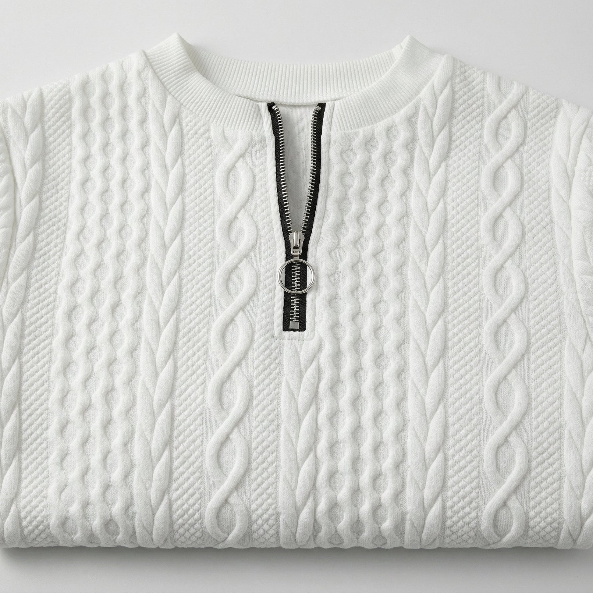 Weißer Strickpullover mit Zopfmuster und kurzem schwarzen Reißverschluss mit rundem Metallanhänger