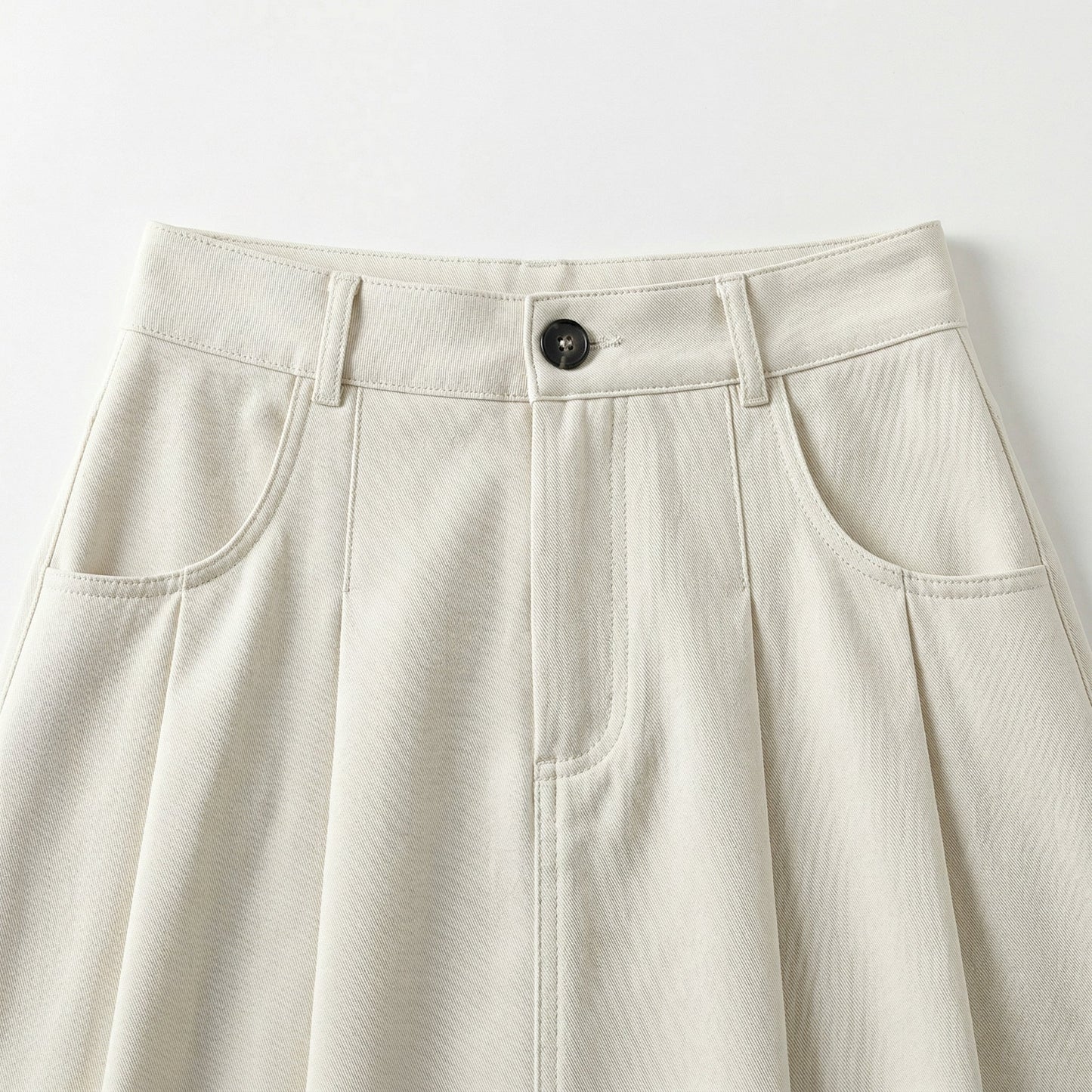 Heller beige A-Linien Rock mit hohem Bund, schwarzem Knopf und vorderen Taschen, Frontdetail
