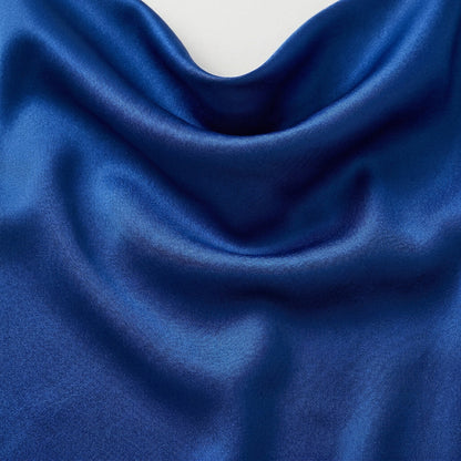 Tiefe königsblaue glänzende Satin-ähnliche Stofftextur mit weichen Falten