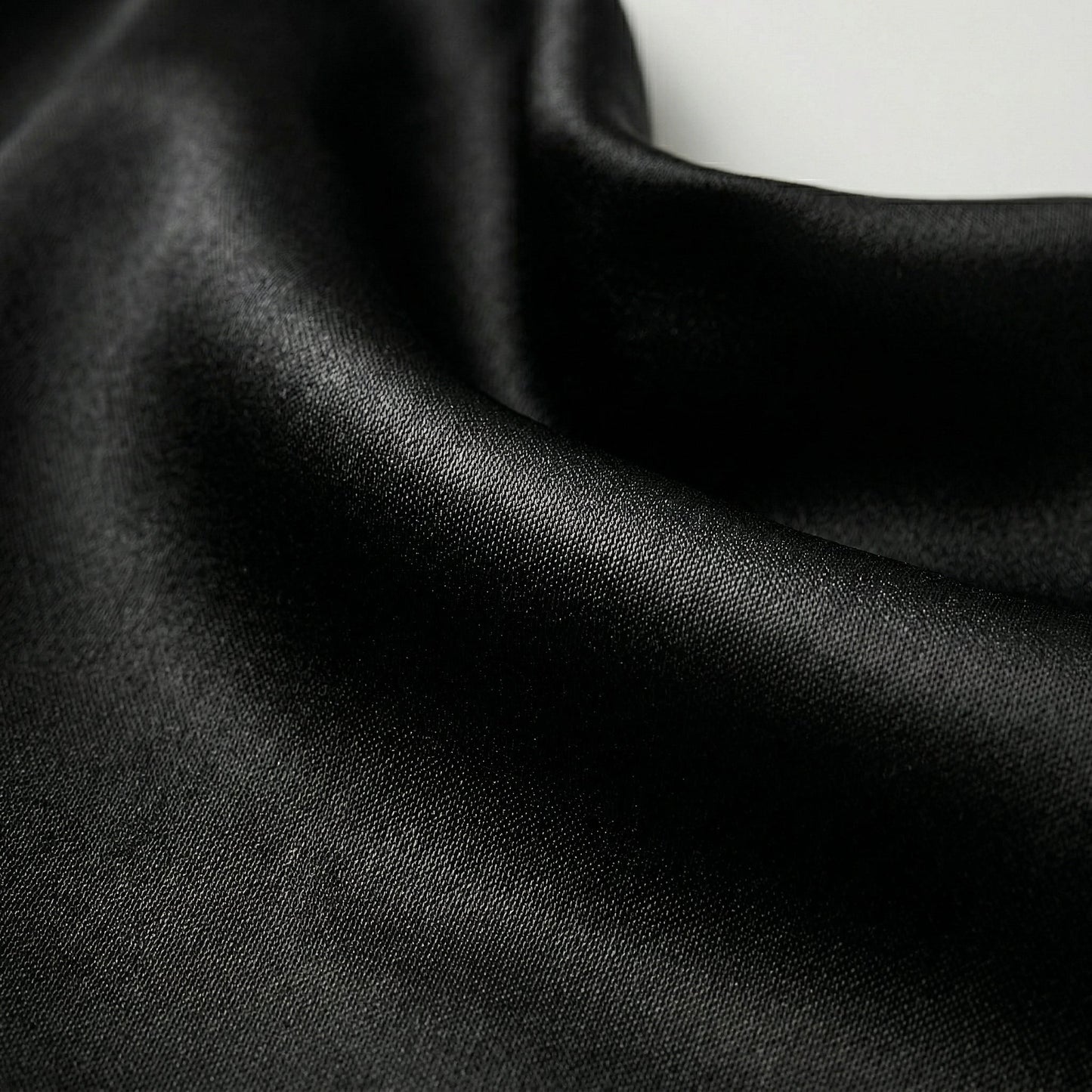 Schwarzer glänzender Satin-Stoff mit feiner Webstruktur und weichem Fall