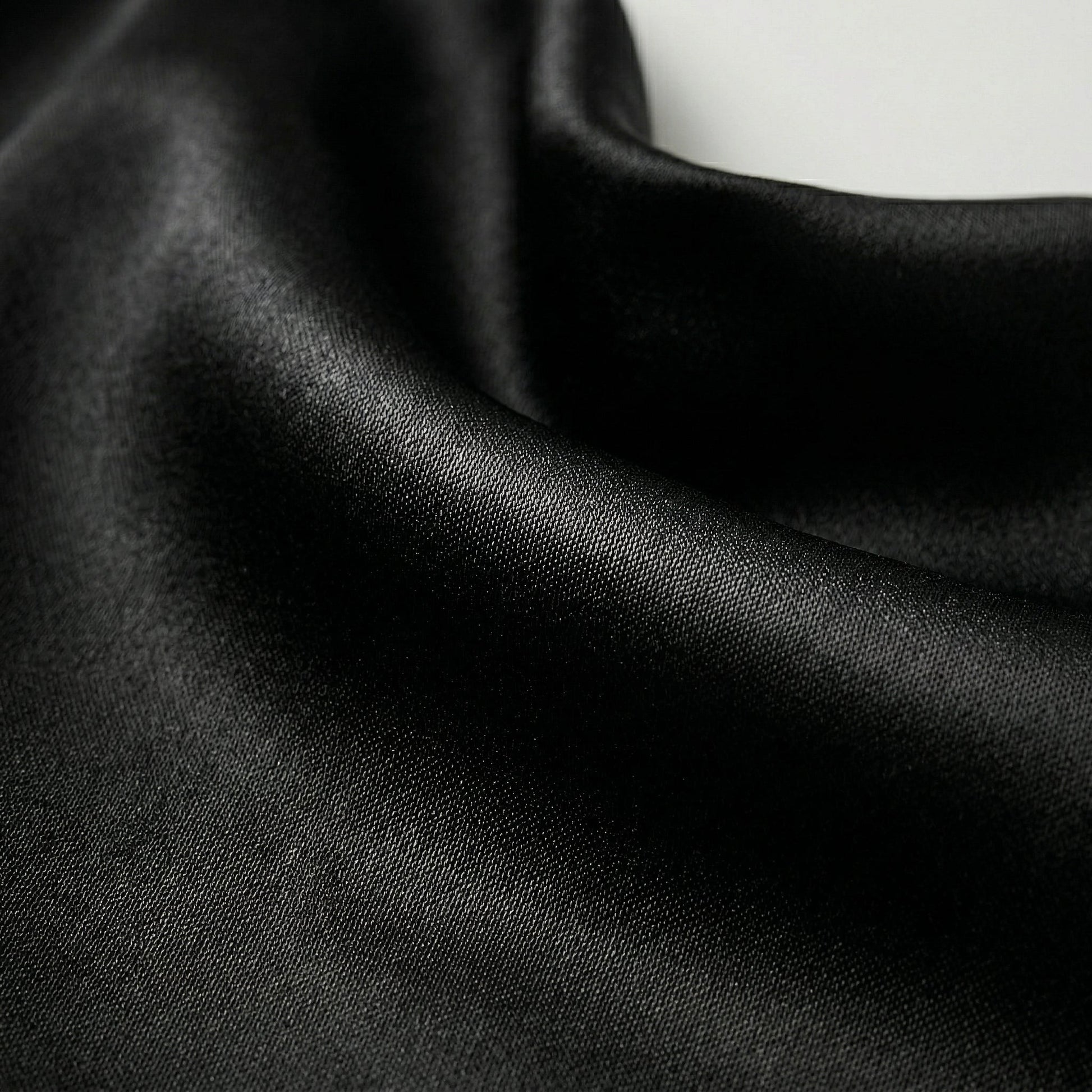 Schwarzer glänzender Satin-Stoff mit feiner Webstruktur und weichem Fall