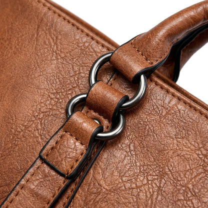 Nahaufnahme braunes PU-Leder mit silbernen Metallringen und gepolstertem Griff an Handtasche
