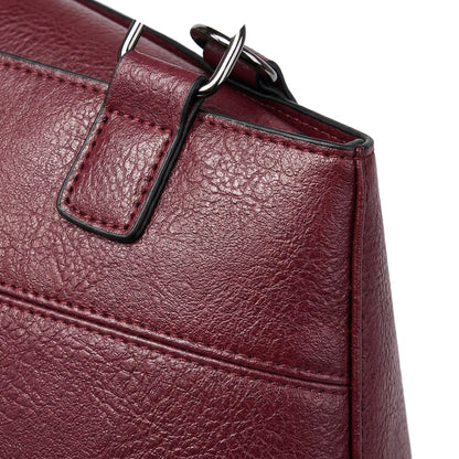 Nahaufnahme burgunderrote strukturierte PU-Ledertasche mit silberner Schnalle und verstärkter Kantennaht