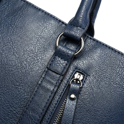 Nahaufnahme dunkelblaue Damenhandtasche aus strukturiertem PU-Leder mit silberfarbenem Reißverschluss und D-Ring