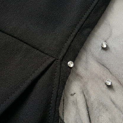 Schwarzes Damenoberteil mit transparentem Mesh-Ärmel und glitzernden Strasssteinen Detailansicht