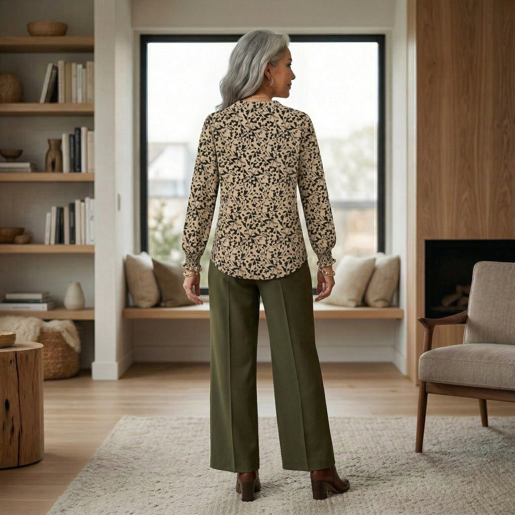 Rückansicht beige Bluse mit schwarzem Blumenmuster und langen Puffärmeln, getragen mit grüner Hose