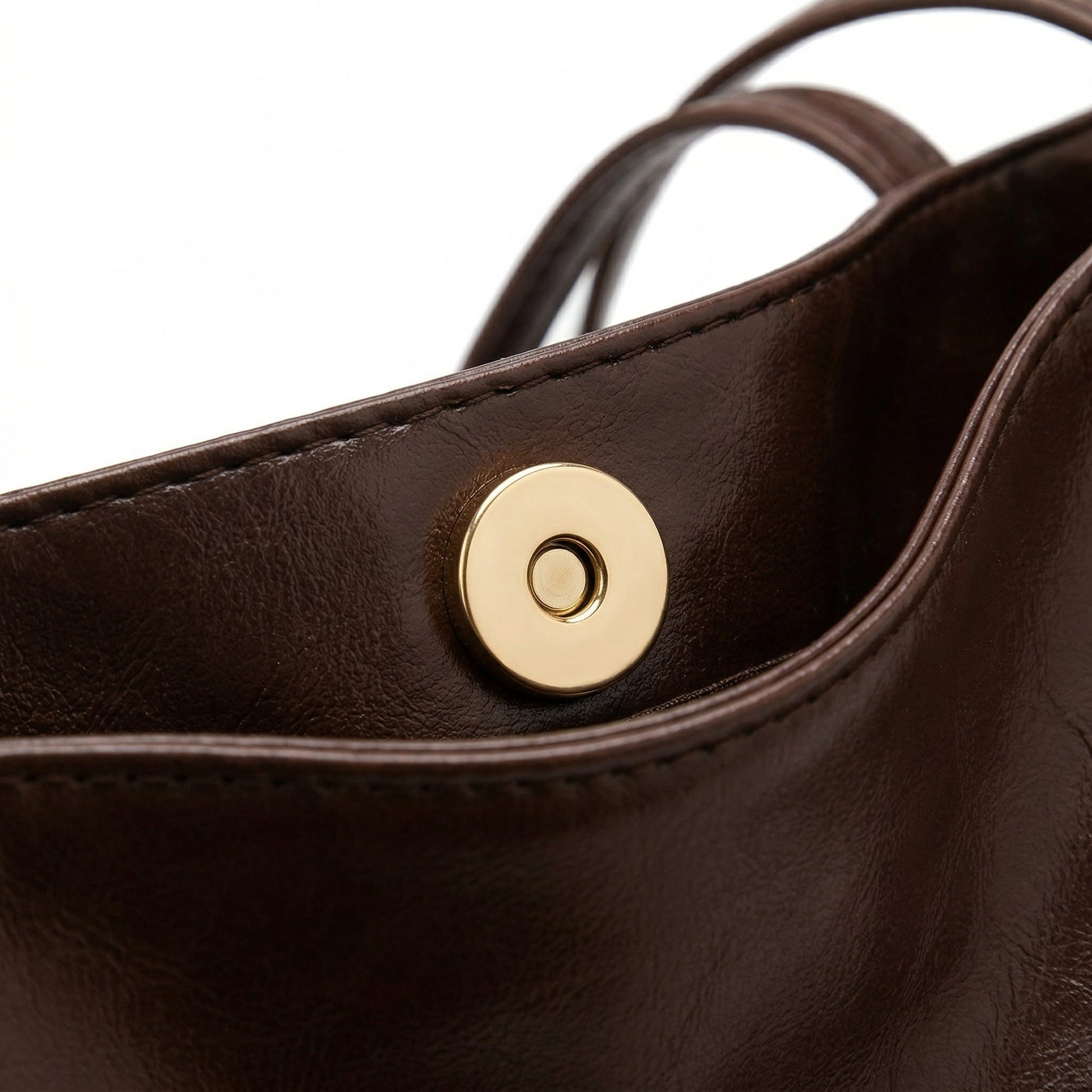 Dunkelbraune Ledertasche mit goldfarbenem Magnetverschluss, Nahaufnahme