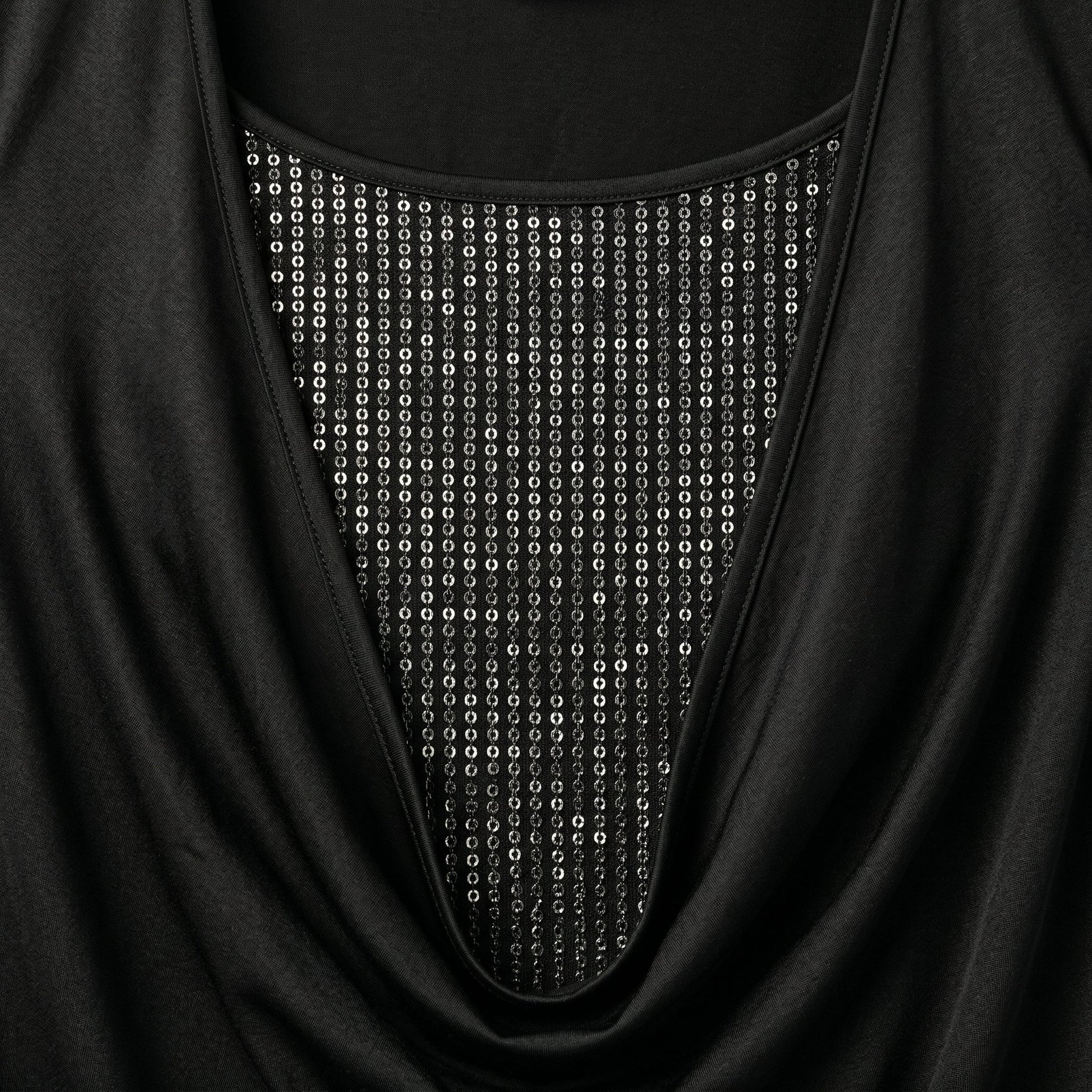 Schwarzes Langarmshirt mit weitem Ausschnitt und silbernen Perlen- oder Paillettenbesatz im Brustbereich