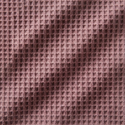 Nahaufnahme eines staubig rosafarbenen Waffelstrickstoffs mit strukturierter Oberfläche